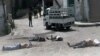 This citizen journalist image provided by The Syrian Revolution against Bashar Assad, which has been authenticated based on its contents and other AP reporting, shows Syrian army soldiers standing in front of dead bodies at Bayda village.